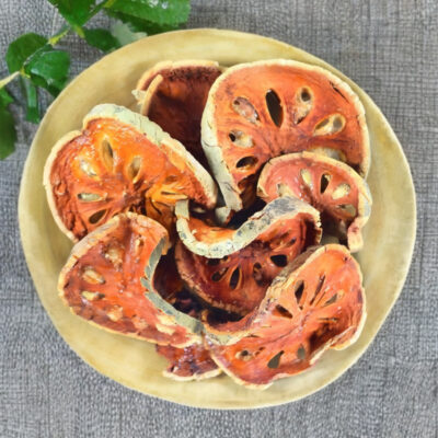 Dried bael fruit slices in a wooden bowl