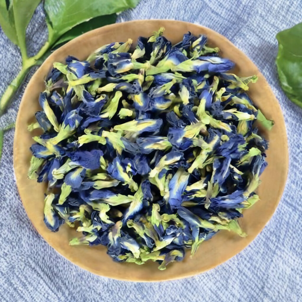 Dried blue butterfly pea flowers in a wooden bowl