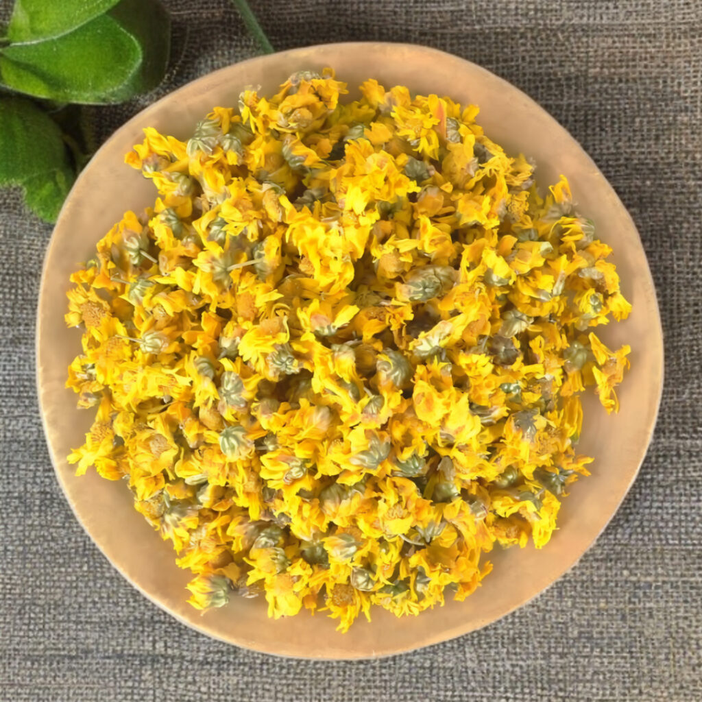 Dried yellow chrysanthemum flowers in a wooden bowl