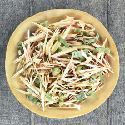 Dried lemongrass and pandan pieces in a wooden bowl