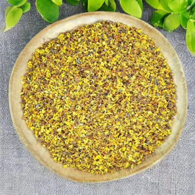 Tiny golden osmanthus flowers in a wooden bowl
