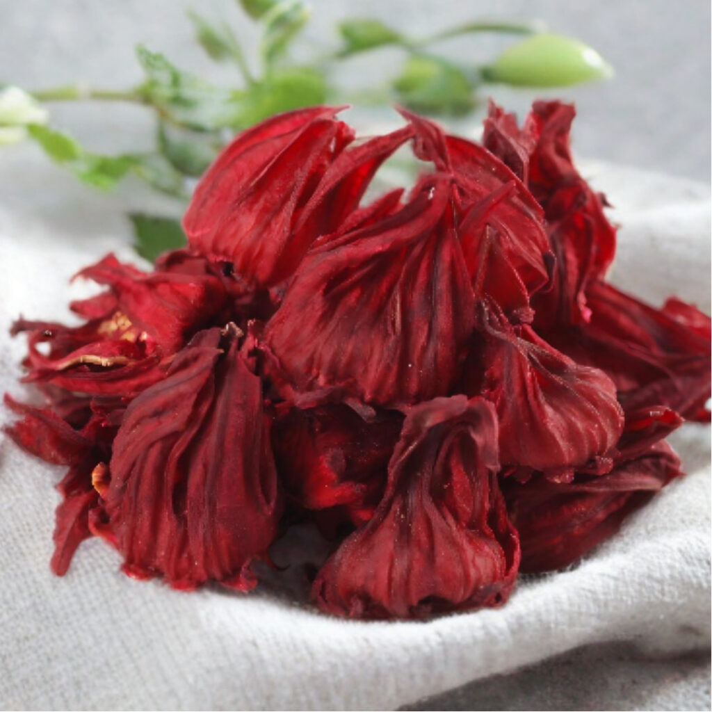 Dried red roselle hibiscus flowers on a white cloth